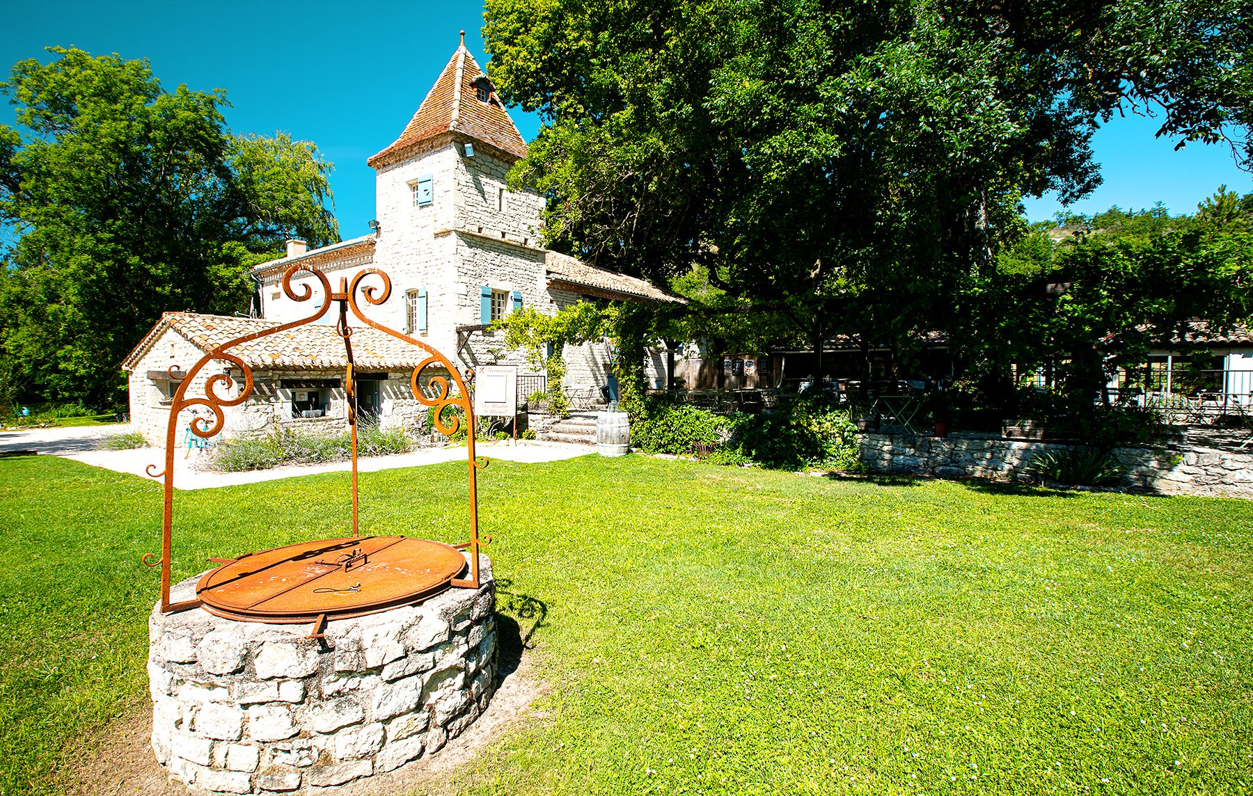 Le jardin arboré et les bâtiments en pierre du Domaine Saint Martial.